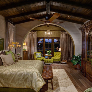Photo of a large mediterranean master bedroom in Orlando with beige walls, dark hardwood floors and brown floor.