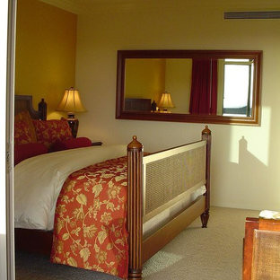 Modelo de dormitorio principal, exótico, con paredes amarillas y moqueta