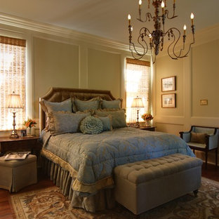 This is an example of a mid-sized victorian master bedroom in New Orleans with beige walls, dark hardwood floors and brown floor.