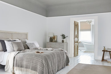 Diseño de dormitorio principal tradicional grande con paredes grises, suelo de madera clara y suelo blanco