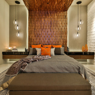 Imagen de dormitorio principal, contemporáneo, grande, con paredes beige, suelo de baldosas de porcelana, chimenea lineal, marco de chimenea de piedra y suelo beige