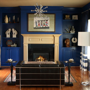 Ejemplo de dormitorio principal, bohemio, grande, con paredes azules, suelo de madera en tonos medios, chimenea tradicional, marco de chimenea de madera y suelo marrón