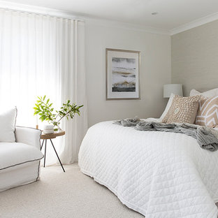 Large beach style master bedroom in Gold Coast - Tweed with white walls, carpet and grey floor.