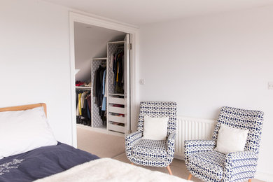 This is an example of a small contemporary master bedroom in London with white walls and carpet.