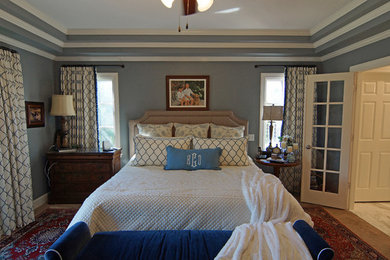 Modelo de dormitorio principal tradicional grande con paredes azules, moqueta y suelo marrón