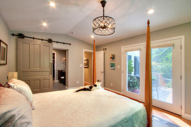 Imagen de dormitorio principal tradicional renovado grande sin chimenea con paredes grises y suelo de madera en tonos medios