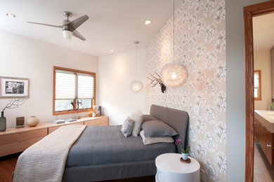 Modelo de dormitorio principal minimalista de tamaño medio con paredes blancas y suelo de madera en tonos medios