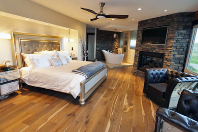 Bedroom - huge rustic master light wood floor bedroom idea in Calgary with white walls, a corner fireplace and a stone fireplace