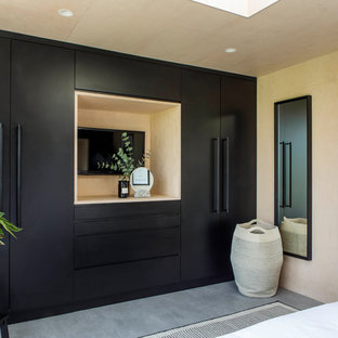 This is an example of a scandi master bedroom in Oxfordshire with beige walls, concrete flooring, no fireplace and grey floors.
