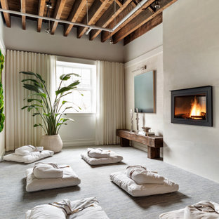 Diseño de habitación de invitados actual, de tamaño medio, con paredes blancas, moqueta, chimeneas suspendidas, marco de chimenea de yeso y suelo azul