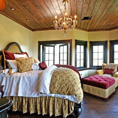 Example of a tuscan dark wood floor bedroom design in Orange County with beige walls
