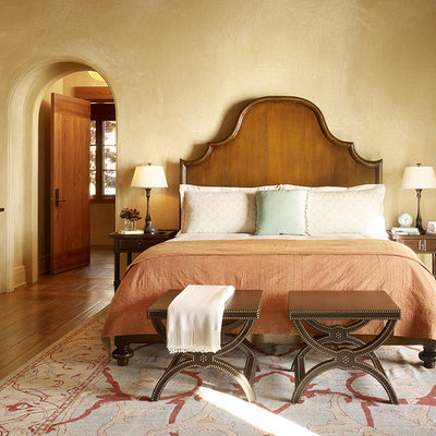 Tuscan medium tone wood floor bedroom photo in San Francisco with beige walls