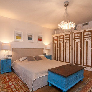 Modelo de dormitorio rústico, de tamaño medio, con suelo de madera en tonos medios
