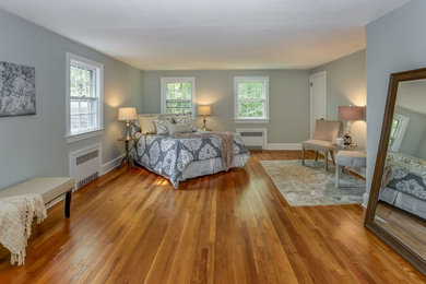Idee per una camera matrimoniale classica con pareti grigie, pavimento in legno massello medio e pavimento marrone