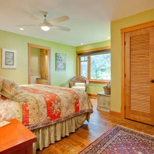 Diseño de dormitorio clásico, de tamaño medio, con paredes verdes, suelo de madera clara y suelo naranja