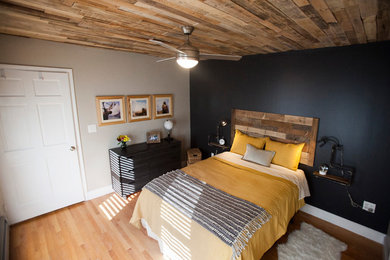 Modelo de dormitorio principal moderno de tamaño medio con paredes grises y suelo de madera en tonos medios
