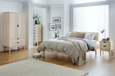 Kleines Klassisches Hauptschlafzimmer mit weißer Wandfarbe, braunem Holzboden und braunem Boden in Sonstige