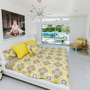 Imagen de habitación de invitados moderna, de tamaño medio, con paredes blancas, suelo de cemento, chimenea tradicional, marco de chimenea de ladrillo y suelo blanco