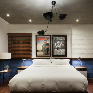 Foto de dormitorio principal, industrial, de tamaño medio, con paredes azules, suelo laminado y suelo marrón