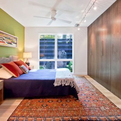 Example of a mid-sized mid-century modern master light wood floor and beige floor bedroom design in Indianapolis with green walls