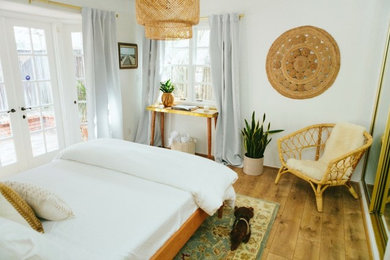 サンディエゴにある小さなミッドセンチュリースタイルのおしゃれな客用寝室 (白い壁、ラミネートの床、茶色い床) のレイアウト