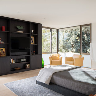 Contemporary bedroom in Denver with white walls and light hardwood flooring.
