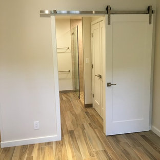 Imagen de dormitorio principal, marinero, de tamaño medio, con paredes blancas, suelo de baldosas de porcelana y suelo beige