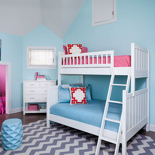 Diseño de dormitorio tipo loft, actual, de tamaño medio, con paredes azules, suelo de madera en tonos medios y suelo gris