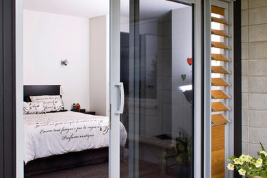 Ejemplo de habitación de invitados minimalista de tamaño medio con paredes blancas y moqueta