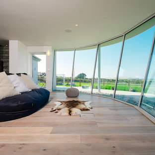 Foto de dormitorio principal, actual, con paredes blancas, suelo de madera clara y estufa de leña