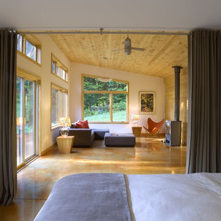 Modernes Schlafzimmer mit weißer Wandfarbe, Betonboden und Kaminofen in Burlington