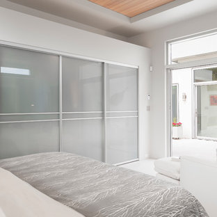 Diseño de dormitorio principal, moderno, grande, sin chimenea, con paredes blancas, suelo de baldosas de cerámica y suelo blanco