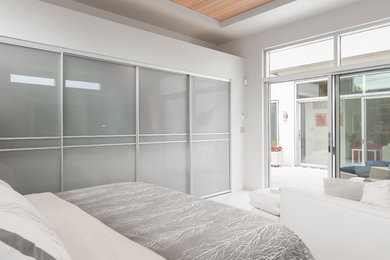 Diseño de dormitorio principal moderno grande sin chimenea con paredes blancas, suelo de baldosas de cerámica y suelo blanco
