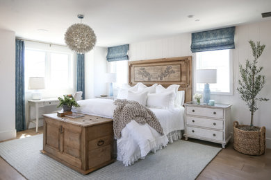 Beach style guest medium tone wood floor and brown floor bedroom photo in Orange County with white walls