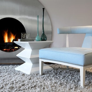 Diseño de habitación de invitados actual con paredes azules, suelo de madera en tonos medios y marco de chimenea de metal