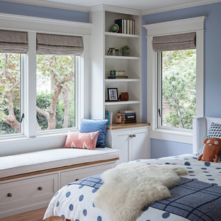 Aménagement d'une chambre d'amis craftsman de taille moyenne avec un mur bleu, un sol en bois brun, aucune cheminée et un sol marron.