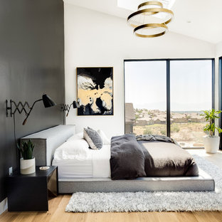 Modelo de dormitorio principal, clásico renovado, grande, sin chimenea, con paredes negras, suelo de madera clara y suelo beige