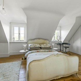 Photo of a medium sized vintage bedroom in London with white walls, medium hardwood flooring and beige floors.