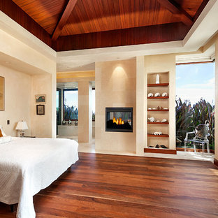 Hauptschlafzimmer mit beiger Wandfarbe, dunklem Holzboden und Tunnelkamin in Santa Barbara