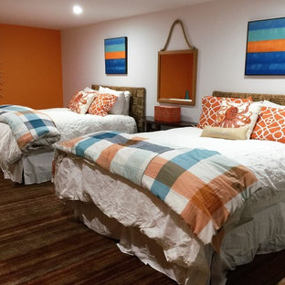 Imagen de habitación de invitados moderna, grande, sin chimenea, con parades naranjas y suelo de travertino