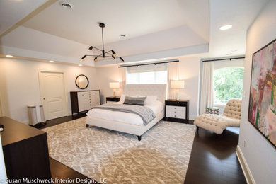 Example of a large trendy master dark wood floor, brown floor and tray ceiling bedroom design in Other with white walls and no fireplace