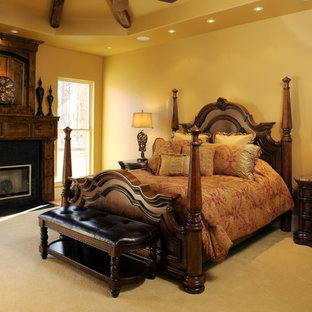 Ejemplo de dormitorio principal, mediterráneo, de tamaño medio, con paredes beige, moqueta, chimenea tradicional y marco de chimenea de madera