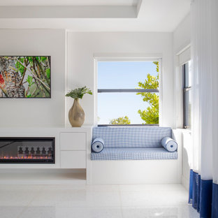 Foto de dormitorio principal, minimalista, grande, con paredes blancas, suelo de mármol, chimeneas suspendidas, marco de chimenea de madera y suelo blanco