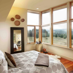 Bedroom - large contemporary master medium tone wood floor bedroom idea in Portland with beige walls