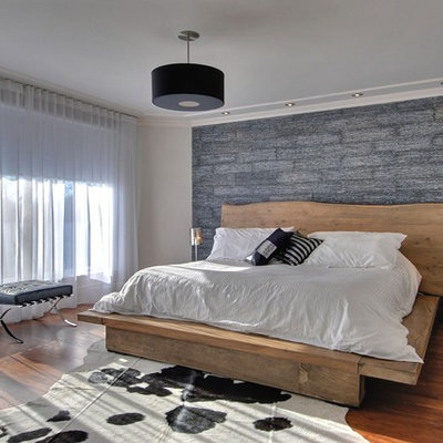 Example of a trendy master medium tone wood floor bedroom design in Montreal with gray walls