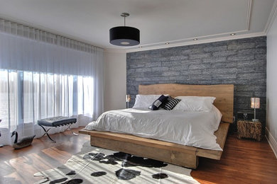 Example of a trendy master medium tone wood floor bedroom design in Montreal with gray walls