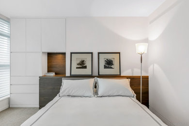 Modelo de dormitorio principal moderno de tamaño medio con paredes blancas, moqueta y suelo gris