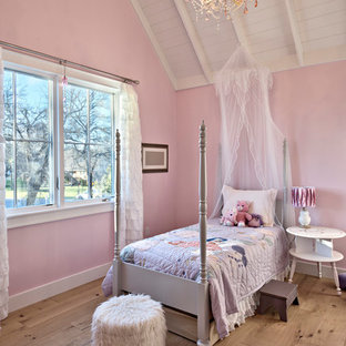 Diseño de dormitorio campestre, de tamaño medio, con paredes rosas y suelo de madera clara