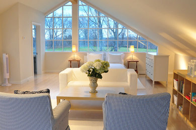 Modelo de habitación de invitados actual sin chimenea con paredes blancas y suelo de madera clara