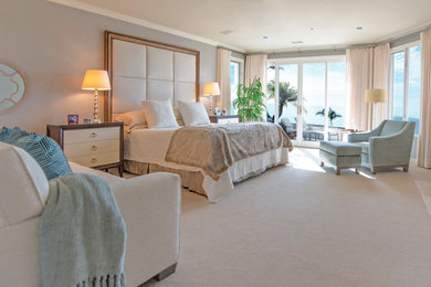 広いコンテンポラリースタイルのおしゃれな主寝室 (カーペット敷き、標準型暖炉、石材の暖炉まわり、グレーの壁、ベージュの床)